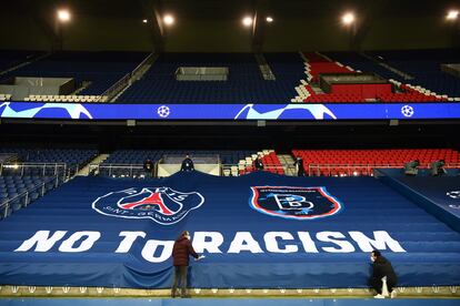 Empleados del estadio del Paris Saint-Germain (PSG) despliegan una pancarta contra el racismo.