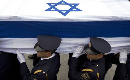 La guardia del Parlamento israel&iacute; transporta el f&eacute;retro del exprimer ministro Ariel Sharon, cubierto por con la bandera nacional.