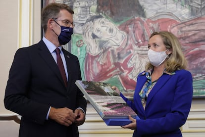 El presidente de la Xunta, Alberto Núñez Feijóo, entrega un libro como regalo a la vicepresidenta Nadia Calviño.