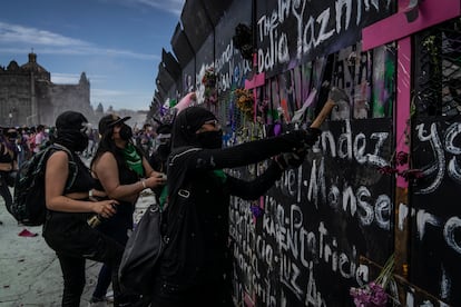 Una mujer golpea una de las vallas instaladas afuera de Palacio Nacional durante la protesta del 8-M en Ciudad de México.