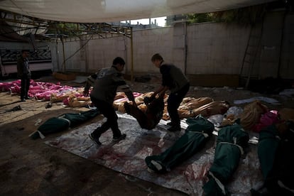 Miembros de la oposición siria reúnen cadáveres en una vivienda después de que las fuerzas gubernamentales bombardearan un concurrido mercado en el barrio de Douma, en Damasco (Siria).