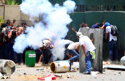 Manifestantes se protegem durante os protestos na Universidade Agrária de Manágua.