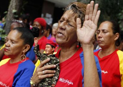 A woman holds a figurine of Ch&aacute;vez as she prays for his health in Caracas on Tuesday