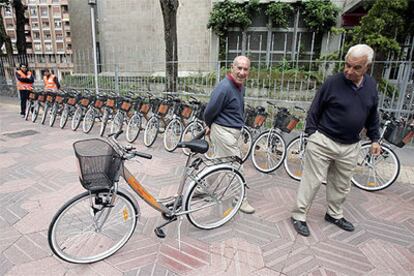 Dos personas contemplan las bicicletas momentos antes de que ayer comenzara la campaña de préstamo gratuito en Vitoria.