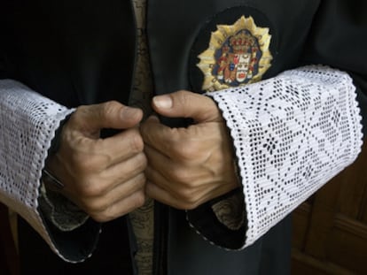 Detalle de las manos de un juez vestido con toga.