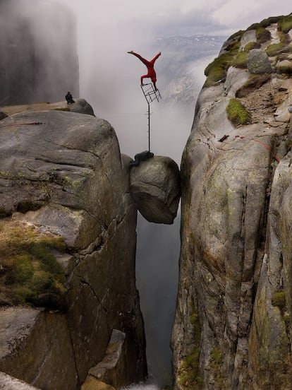 Por sí solas. Poco más se necesita que mirarlas para sobrecogerse con el vértigo que provocan. Son las fotografías del acróbata noruego Eskil Ronningsbakken, un equilibrista singular que se juega la vida para perseguir no la gloria de los Guinnes, sino la belleza plástica de una imagen. En la superior, tomada en 2008, el arista se encuentra equilibrado en una silla con traje rojo, en Kjeragbolten (Noruega), a una altura de 1.000 metros.