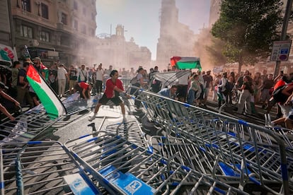 Manifestantes tiran las vallas al suelo durante la última etapa de la Vuelta celebrada en Madrid, este domingo. 
