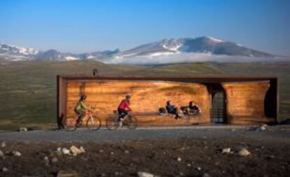 Ciclistas en el parque natural Langedrag pasando por el mirador proyectado por el estudio Snoheta.