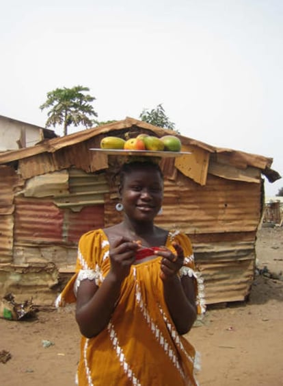 Una mujer gambiana porta mangos en la cabeza