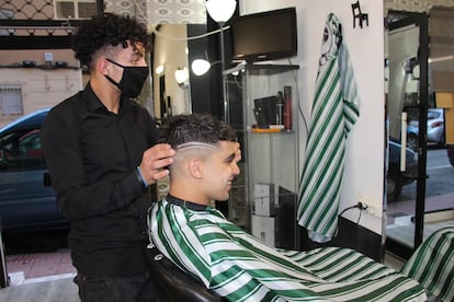 El joven Otman corta el pelo a uno de los primeros clientes en 'La Pelu de Maakum'.