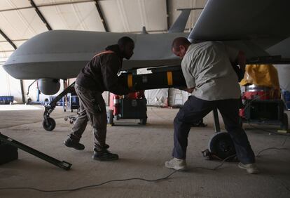 Dos trabajadores colocan un misil Hellfire en un dron de la Fuerza Aérea Estadounidense, en un base aérea secreta en la región del Golfo Pérsico.