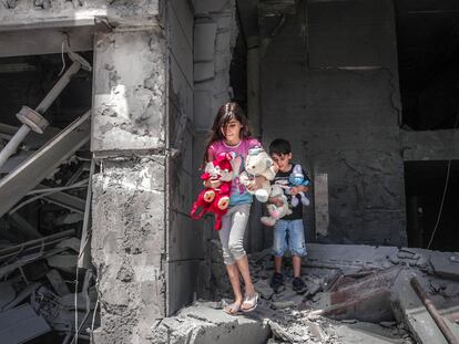 Niños palestinos rescatan juguetes de su casa, que resultó gravemente dañada por los ataques aéreos israelíes, en la Torre Al-Jawhara en Gaza, el pasado 17 de mayo.