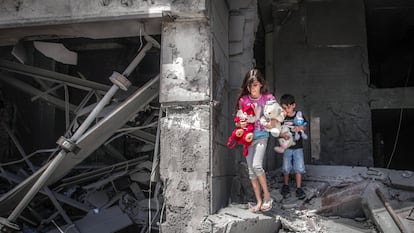 Niños palestinos rescatan juguetes de su casa, que resultó gravemente dañada por los ataques aéreos israelíes, en la Torre Al-Jawhara en Gaza, el pasado 17 de mayo de 2021.