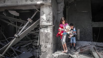 Niños palestinos rescatan juguetes de su casa, que resultó gravemente dañada por los ataques aéreos israelíes, en la Torre Al-Jawhara en Gaza, el pasado 17 de mayo.