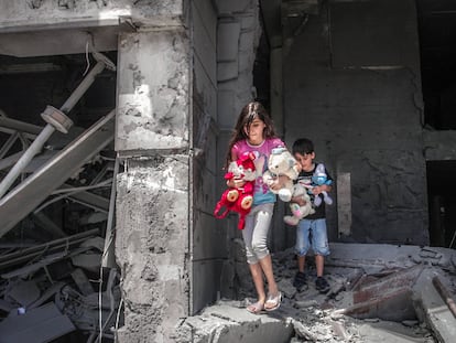 Niños palestinos rescatan juguetes de su casa, que resultó gravemente dañada por los ataques aéreos israelíes, en la Torre Al-Jawhara en Gaza, el pasado 17 de mayo de 2021.