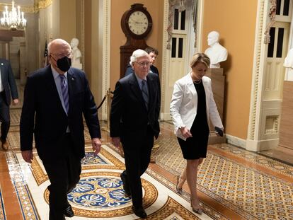 El líder de los republicanos en el Senado, Mitch McConnell (en el centro), junto al senador demócrata por Vermont Patrick Leahy (a la izquierda), en los pasillos del Capitolio, antes de la aprobación de la ley.