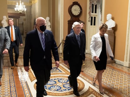 El líder de los republicanos en el Senado, Mitch McConnell (en el centro), junto al senador demócrata por Vermont Patrick Leahy (a la izquierda), en los pasillos del Capitolio, antes de la aprobación de la ley.