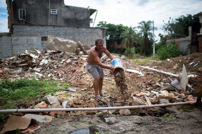 Francisco Marinho limpia los alrededores de su casa para evitar que el agua, proveniente de cañerías rotas, se estanque y promueva la proliferación de mosquitos, en plena crisis por el virus del Zika.