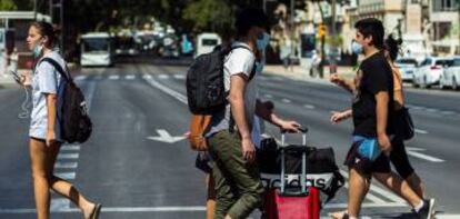 Varios turistas con maletas caminan por el centro de Málaga.