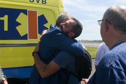 El presidente de la Xunta, Alfonso Rueda (a la izquierda), abraza a uno de los españoles recién llegados de Malvinas en el aeródromo militar de Santiago de Compostela, este domingo.