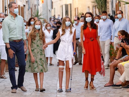 Felipe VI y la reina Letizia con sus hijas, la princesa Leonor y la infanta Sofía, que aparece lesionada en la rodilla, durante su paseo por las calles de Petra, en Mallorca.