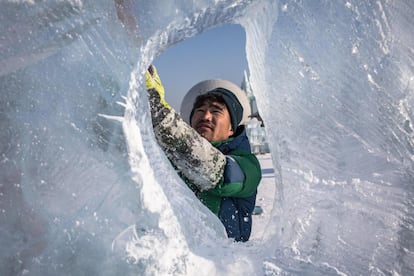 Um artista molda sua escultura de gelo durante uma competição realizada no Harbin Ice and Snow Festival. A competição de escultura de gelo atraiu 64 artistas de 12 países que testaram suas habilidades com até dez blocos de gelo por equipe.