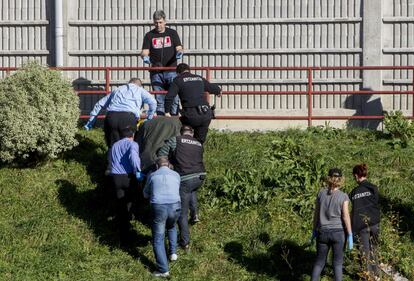 Personal de la funerària i agents de l'Ertzaintza traslladen el cos sense vida d'una dona morta aquest diumenge a Bilbao.