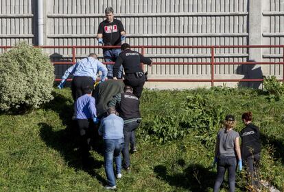 Personal de la funeraria y agentes de la Ertzaintza trasladan el cuerpo sin vida de una mujer fallecida este domingo en Bilbao.