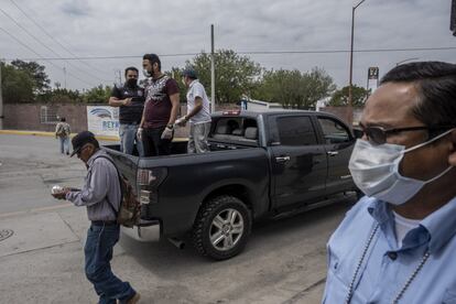Voluntarios reparten comida desde un vehículo a los migrantes y deportados que permanecen varados a las afueras de un refugio en la frontera. Ante la emergencia por el coronavirus, muchos de estos albergues han tenido que cerrar y permanecer en cuarentena.