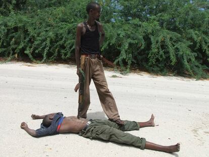 Un soldado gubernamental apunta al cadáver de un combatiente islamista en el bario de Taleh, al sur de la capital Mogadiscio. Las fuerzas gubernamentales han lanzado una ofensiva sobre zonas controladas por las milicias islámicas.