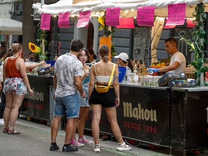 Varias personas comparten, durante las Fiestas de San Lorenzo, en Madrid en agosto de 2023.