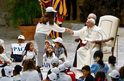 Pope Francis shakes hands with a girl