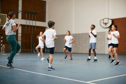 Un grupo de niños haciendo deporte con su entrenadora