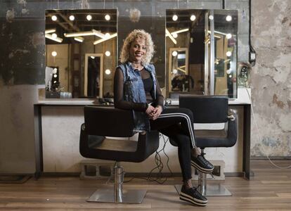 Ivanna García posa sentada en la peluquería donde trabaja en Madrid.