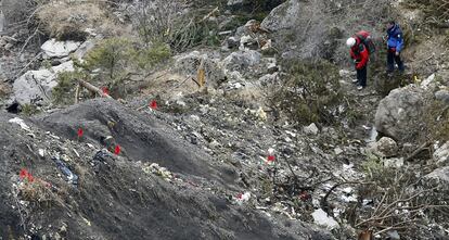 Unos miembros de los servicios de rescate caminan entre fragmentos del avin esparcidos por un rea de alta monta?a en los Alpes franceses.