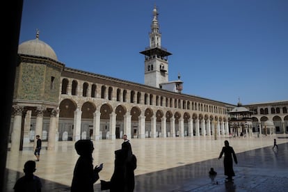 Várias pessoas passeiam em frente à mesquita Umayyad, o 14 de setembro de 2018, em Damasco.