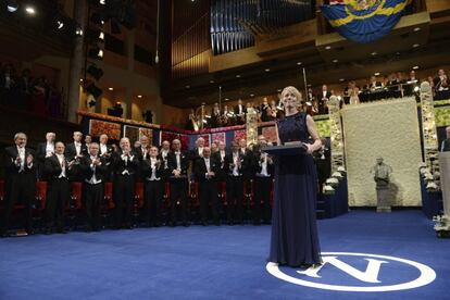 Jenny Munro, hija de la premio Nobel de Literatura 2013 Alice Munro, sostiene el galardón durante la ceremonia de entrega de los Premios Nobel, en la Sala de Conciertos de Estocolmo (Suecia).