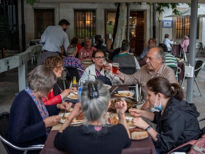 A group of people dining at a sidewalk café in Ourense.