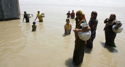 Mujeres y niños recogen agua en el río Yamuna, en India.