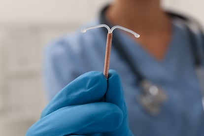 Un médico coge un DIU en forma de "T"