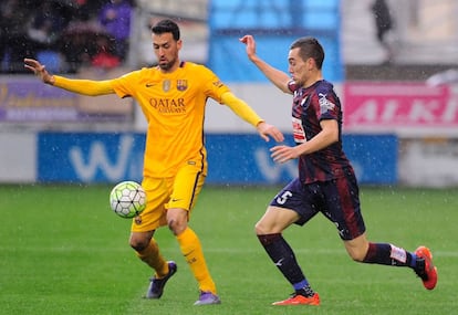 El centrocampista Sergio Busquets intenta retener el balón frente al jugador del Eibar Gonzalo Escalante.