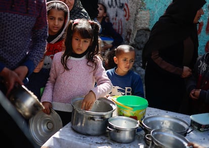Unos niños palestinos esperan a recibir comida de una organización benéfica este martes, mientras hay  escasez de alimentos, en Rafah.