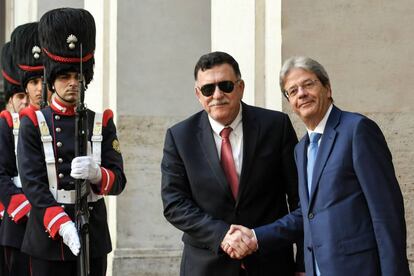 Paolo Gentiloni (derecha) estrecha la mano del primer ministro libio, Fayez al-Sarraj.