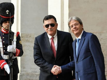 Paolo Gentiloni (derecha) estrecha la mano del primer ministro libio, Fayez al-Sarraj.