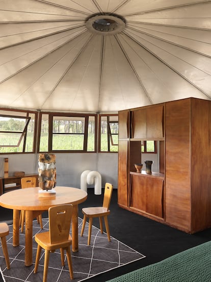 Interior de la Casa Marabout decorada por Clément Cividino con piezas de colección. Mesa de comedor (1968) de Charlotte Perriand, sillas de René Martin, cerámicas (1960) de Jean Paul y Suzy Brunet / Atelier Palègre y librería producida en los talleres de Jean Prouvé.