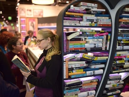 Una mujer lee un libro en la Feria de Fr&aacute;ncfort, que se clausura hoy.