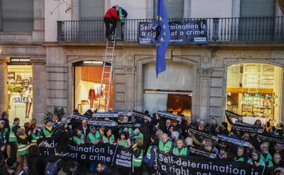 Dos activistas de la ANC descienden del balcón de la sede de la Comisión Europea tras colgar la pancarta.