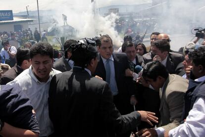 El presidente de Ecuador, Rafael Correa (en el centro, con corbata verde) sale junto con sus escoltas del cuartel de la policía de Quito tras la rebelión de los agentes.