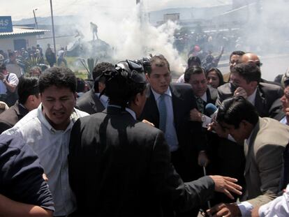 El presidente de Ecuador, Rafael Correa (en el centro, con corbata verde) sale junto con sus escoltas del cuartel de la policía de Quito tras la rebelión de los agentes.