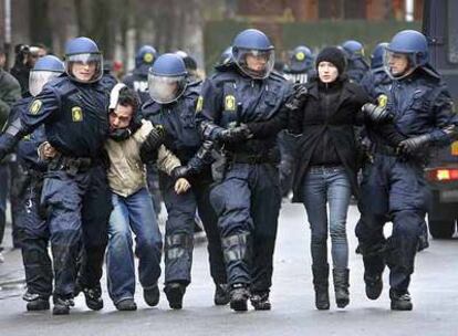 La policía antidisturbios detiene a dos jóvenes tras los enfrentamientos de ayer en Copenhague.